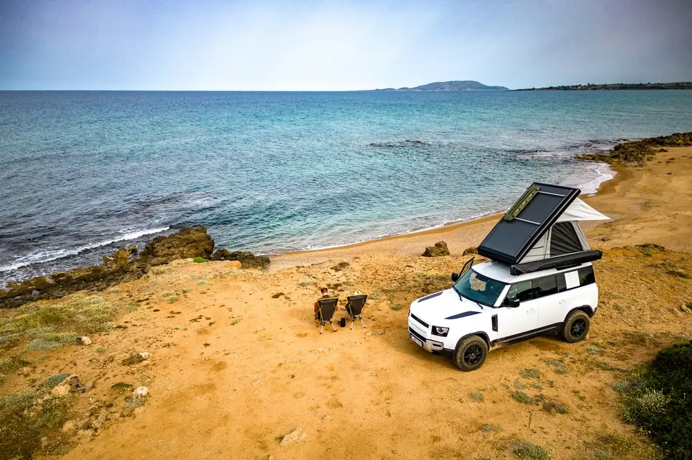 Outdoor Camping Adventure with roof tent on all terrain vehicle on the beach